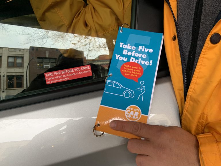 Fleet manager holding "Take 5 before you drive" pamphlet