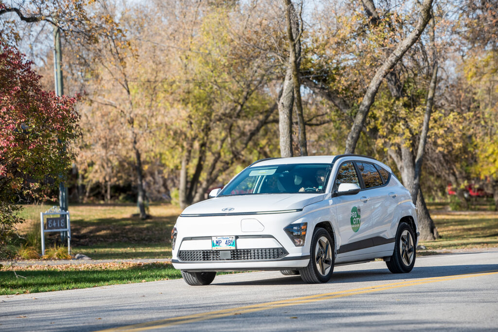 Peg City member drives down the road in an EV. There's no better way to reduce fuel use.